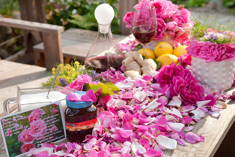 Een tafel met allerlei ingrediënten, zoals rozenblaadjes, om rozengelei van te maken